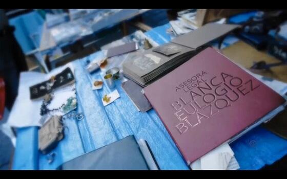 Mesa de trabajo con portátil, taza y apuntes de EB Abogados